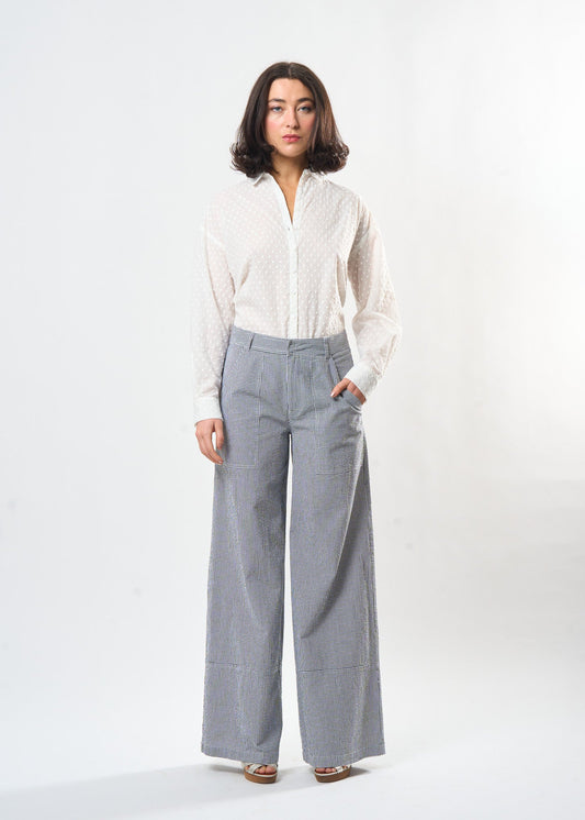 Woman wearing a white blouse and gray checkered pants on a white background