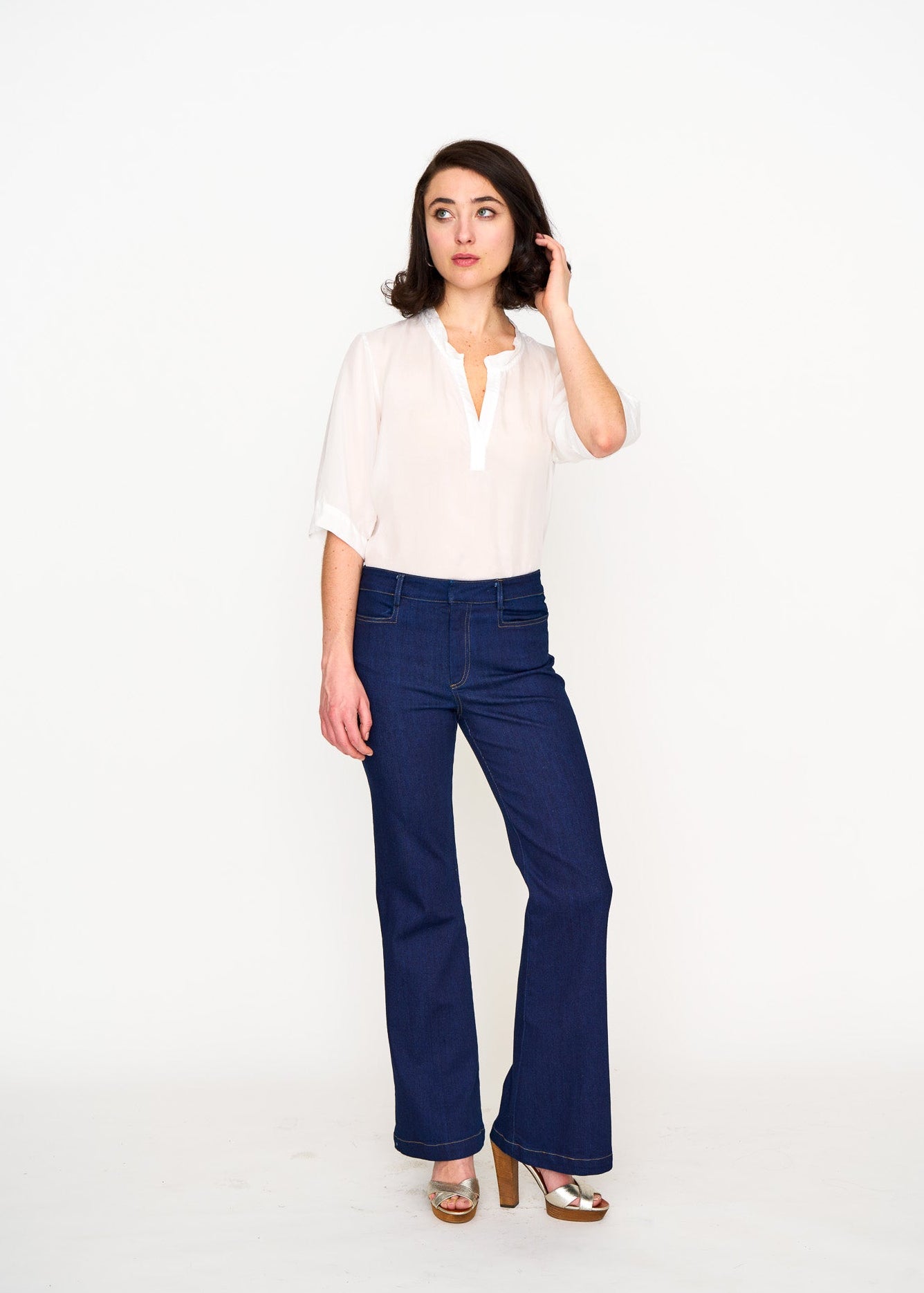 Woman wearing a sheer white silk tee shirt with blue jeans