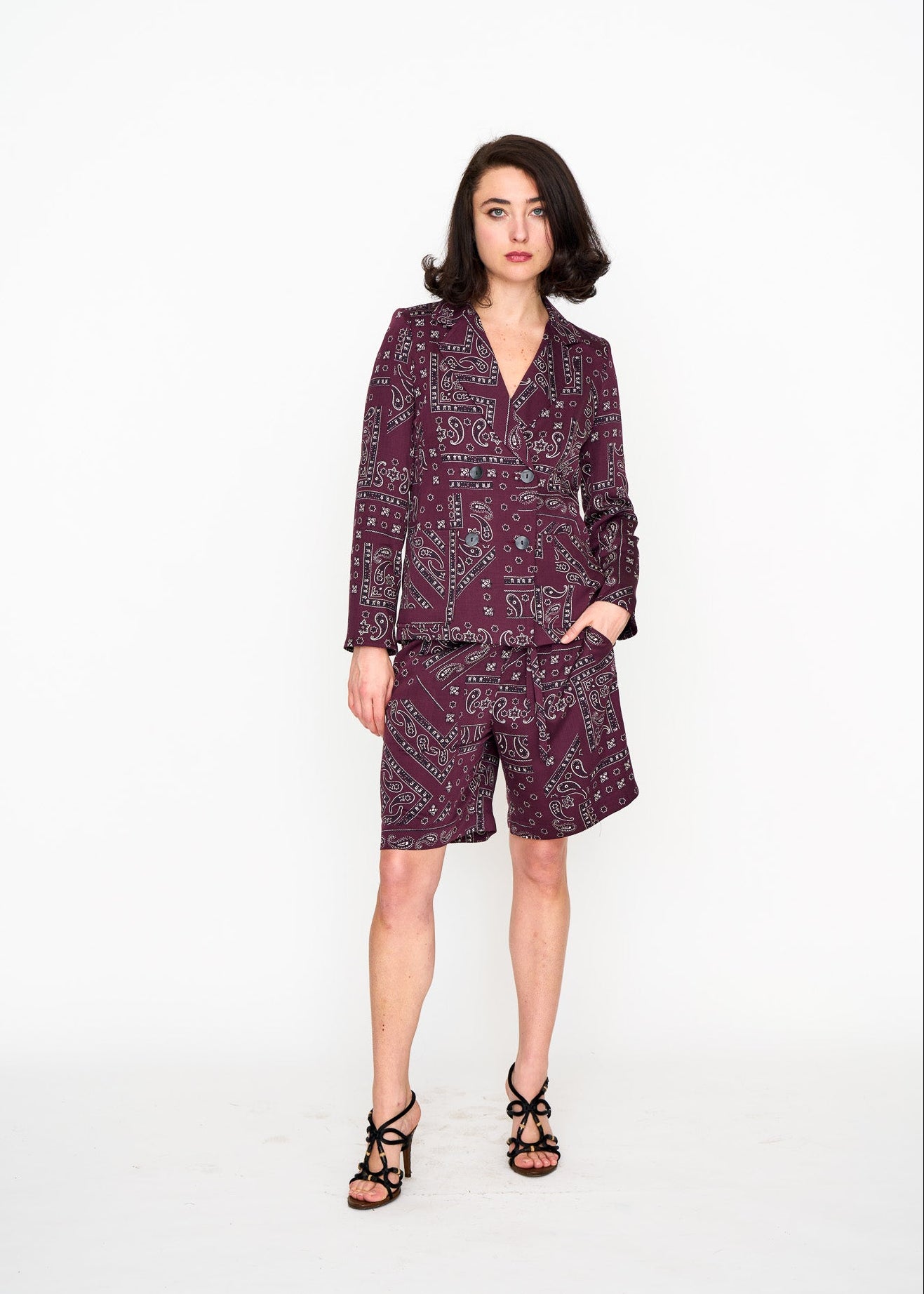 Woman wearing a patterned suit short set in a dark red pattern
