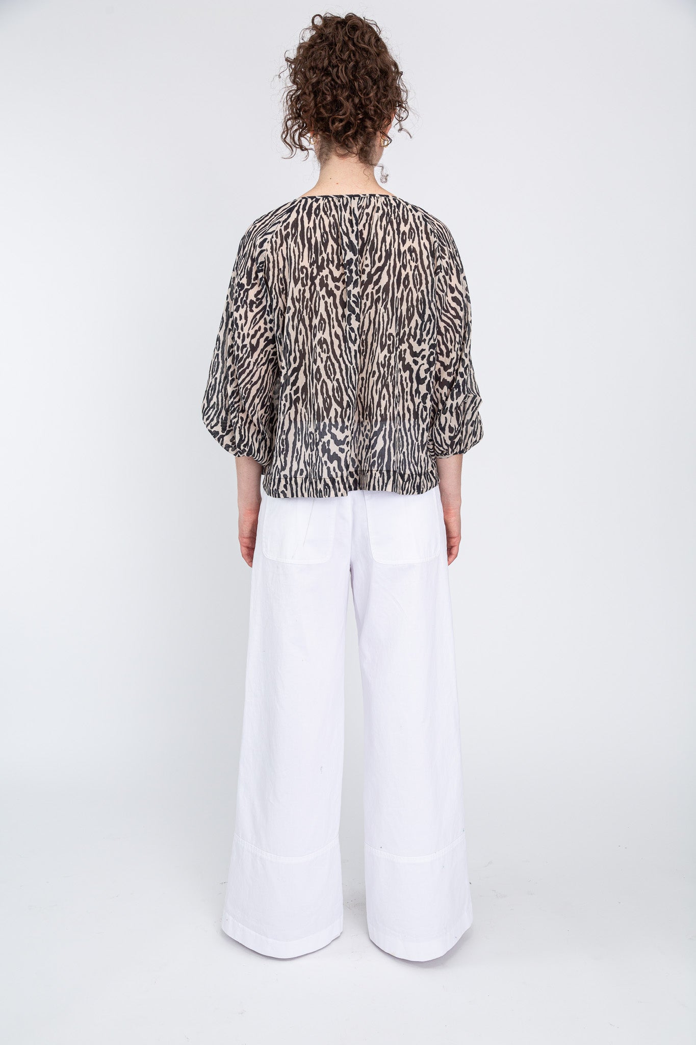 back view of summer blouse over white pants