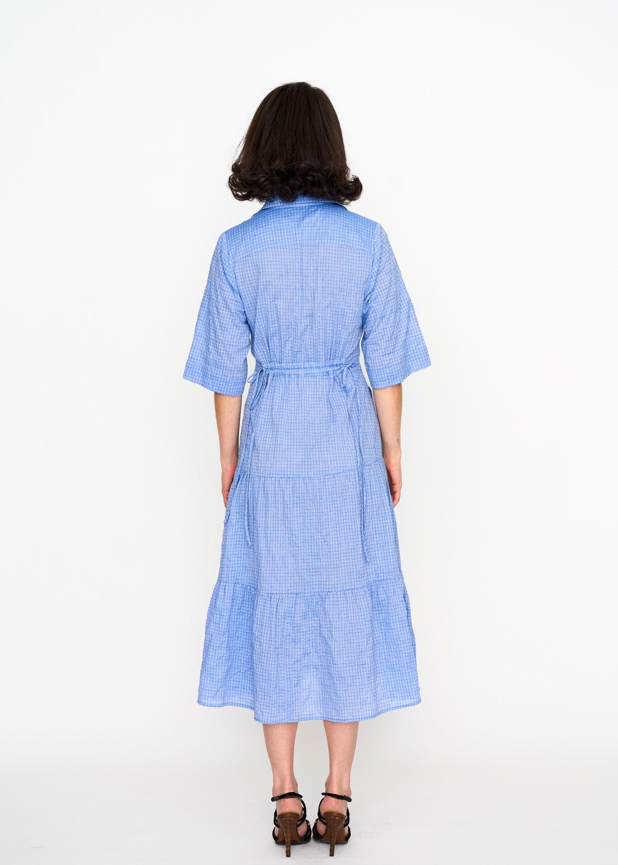 Woman wearing a blue dress with adjustable waist ties